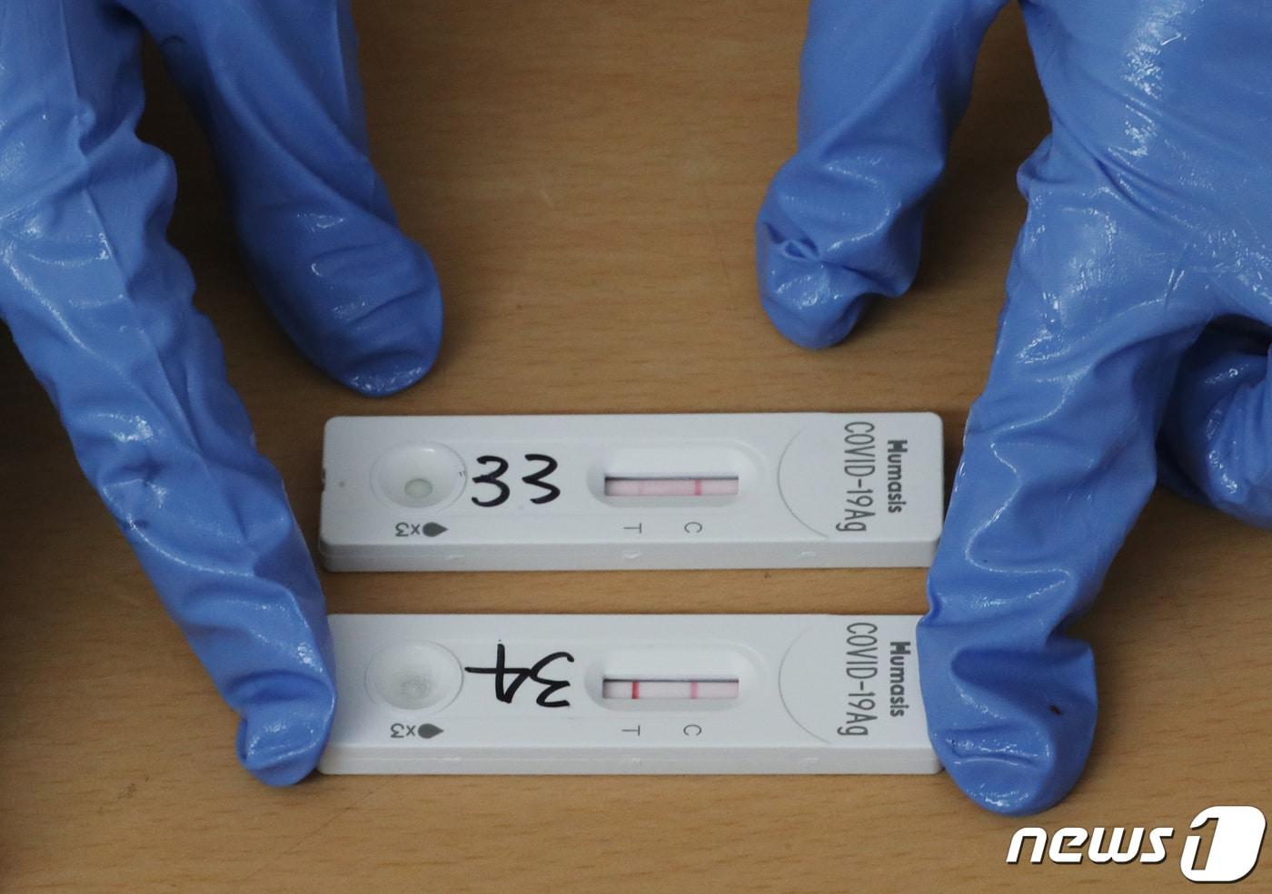 평택, 안성, 광주, 전남 등 4개 지역이 신종 코로나바이러스 감염증(코로나19) 오미크론 변이 확산에 맞춰 새로운 방역체계인 '오미크론 대응단계'가 시작된 26일 오전 경기도 안성시보건소 선별진료소에서 의료진이 신속항원검사 결과가 양성으로 나온 키트를 살펴보고 있다. 2022.1.26/뉴스1 ⓒ News1 김영운 기자