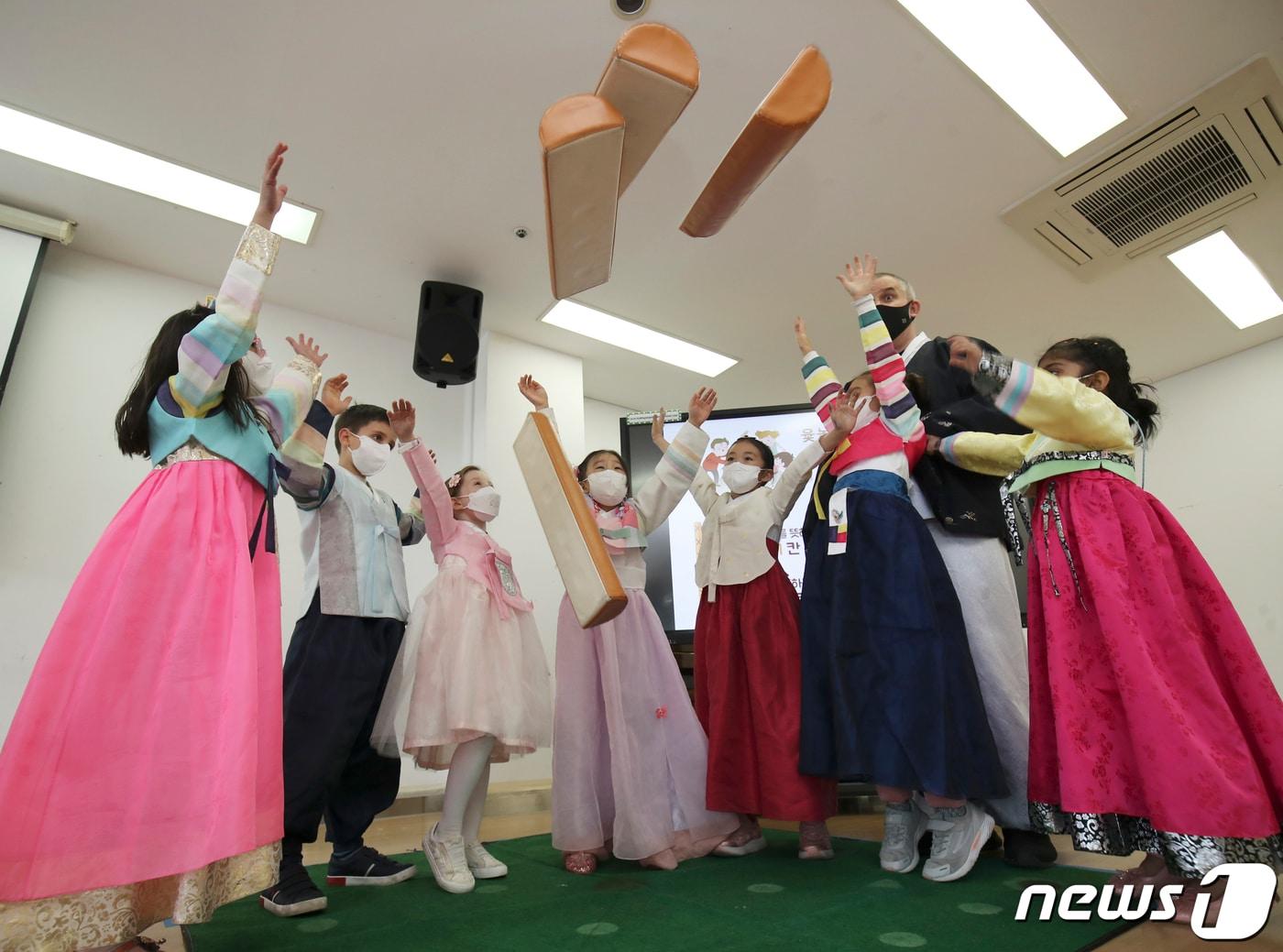 본문 이미지 - 설 명절를 앞둔 27일 오후 울산 동구 현대외국인학교에서 열린 설 맞이 한국문화 체험 행사에서 한복을 곱게 차려 입은 외국인 학생들이 윷놀이를 하고 있다. 2022.1.27/뉴스1 ⓒ News1 윤일지 기자