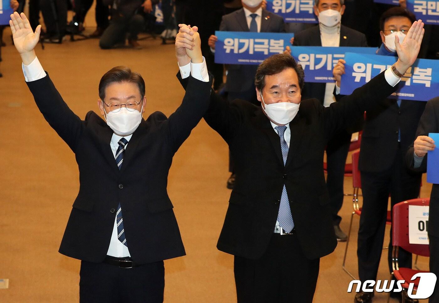 본문 이미지 - 이재명 더불어민주당 대선후보와 이낙연 전 대표가 지난 5일 오전 광주 서구 김대중컨벤션센터에서 열린 '국가비전·국민통합위원회 첫 번째 비전회의'에서 함께 팔을 들어올리고 있다. 2022.1.5/뉴스1 ⓒ News1 이동해 기자