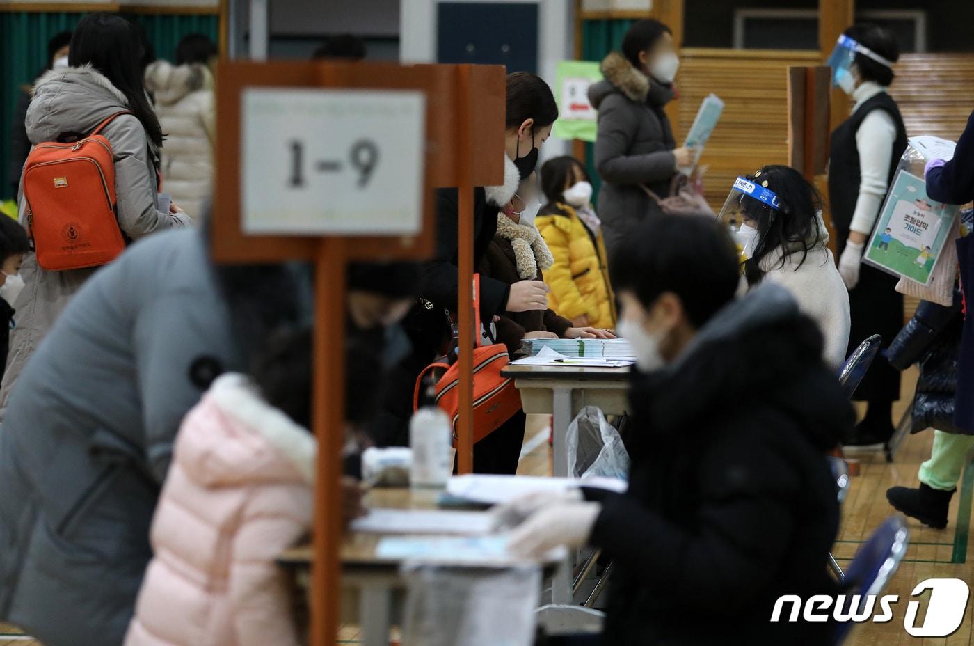 본문 이미지 - 2022학년도 신입생 예비소집일인 5일 오후 서울 노원구의 한 초등학교에서 예비 초등학생과 학부모가 입학 서류 작성을 마치고 학교 안내문을 받고 있다. 2022.1.5/뉴스1 ⓒ News1 김진환 기자