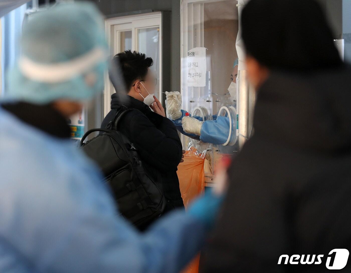 본문 이미지 - 신종 코로나바이러스 감염증(코로나19) 신규 확진자가 4126명 발생한 6일 오전 서울 중구 서울역광장에 마련된 선별진료소를 찾은 한 시민이 의료진에게 검체검사를 받고 있다.2022.1.6/뉴스1 ⓒ News1 김진환 기자