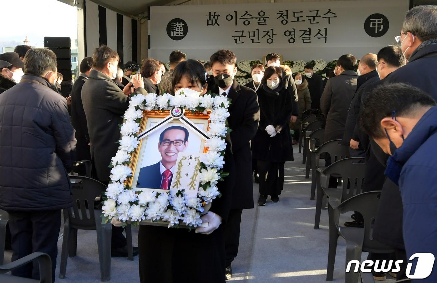 본문 이미지 - 6일 오전 경북 청도군청 광장에서 고 이승율 군수 영결식이 엄수됐다. 고인의 큰딸 이윤정씨가 영정사진을 들고 영결식장을 나오고 있다. (청도군 제공) 2022.1.6/뉴스1 ⓒ News1 정우용 기자