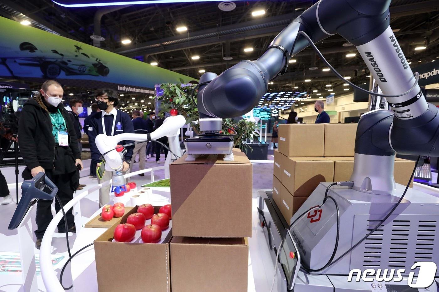 세계 최대 전자·가전·정보기술(IT) 전시회인 CES 2022가 개막한 5일(현지시간) 미국 네바다주 라스베이거스 컨벤션센터에 마련된 두산그룹 부스에서 관람객들이 협동로봇을 살펴보고 있다. 2022.1.6/뉴스1 ⓒ News1 조태형 기자