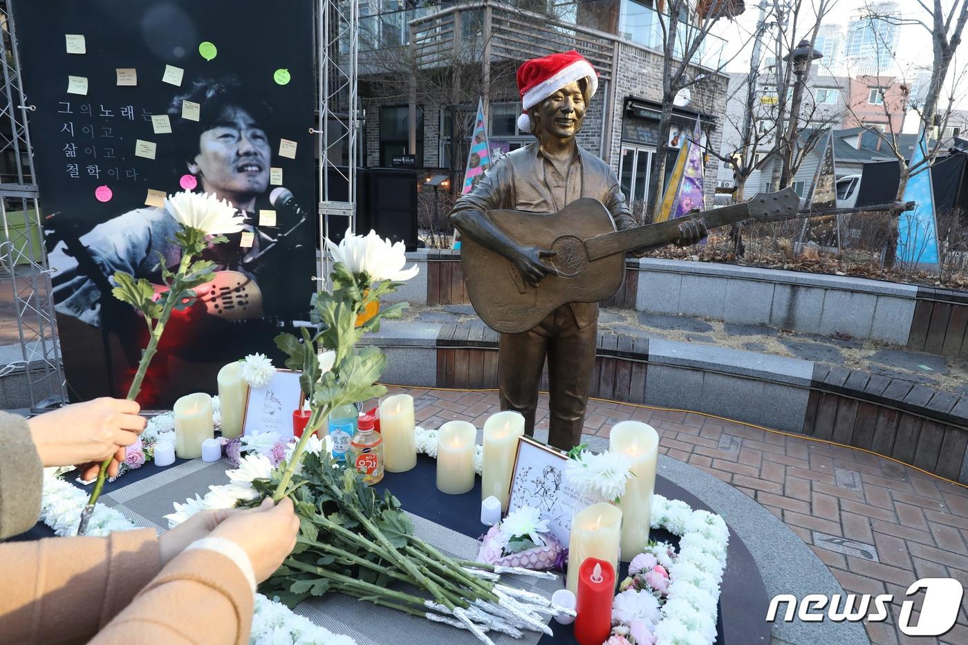 본문 이미지 - '영원한 가객' 고(故) 김광석(1964∼1996)의 27주기를 맞아 오는 6일 대구 중구 대봉동 방천시장 '김광석다시그리길'(김광석길)에서 그의 삶을 기리는 추모 행사가 열린다. 사진은 지난해 열린 26주기 추모제에서 시민들이 헌화하는 모습. 2022.1.6/뉴스1 ⓒ News1 공정식 기자