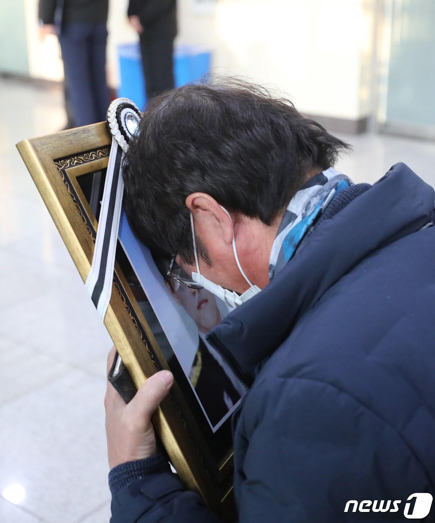 본문 이미지 - 경기도 평택의 한 신축 공사장 화재로 3명의 소방관이 순직한 6일 오후 경기도 평택시 제일장례식장에서 한 유가족이 순직한 소방관의 영정사진을 허망하게 보고 있다. 2022.1.6/뉴스1 ⓒ News1 김영운 기자