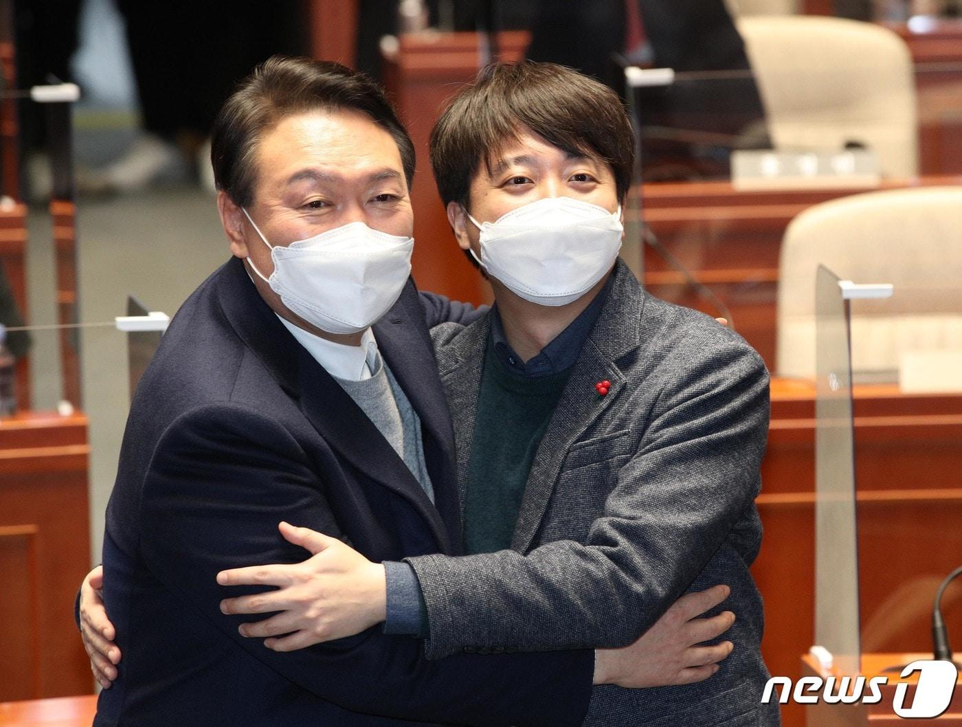 본문 이미지 - 지난 1월 6일 당시 국민의힘 윤석열 대선 후보와 이준석 대표가 서울 여의도 국회에서 열린 의원총회에서 화해하며 포옹하고 있다. ⓒ News1 DB