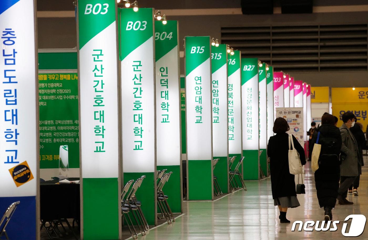 7일 서울 서초구 양재aT센터에서 열린 '2022학년도 정시 전문대학 입학정보박람회‘를 찾은 수험생들과 학부모들이 대학 부스를 둘러보고 있다. 2022.1.7/뉴스1 ⓒ News1 권현진 기자