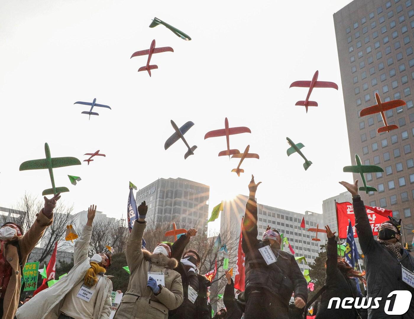 본문 이미지 - 서울 종로구 보신각 앞에서 열린 여행인 총궐기대회에서 한국여행업협회 등 참석자들이 비행기 모형을 날리는 퍼포먼스를 하고 있다. 2022.1.9/뉴스1 ⓒ News1 성동훈 기자