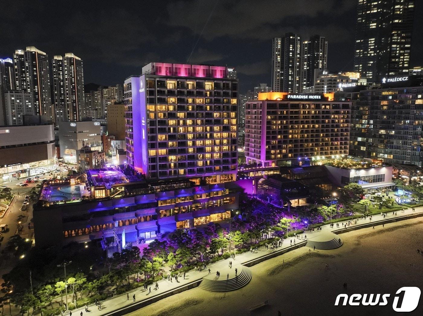 본문 이미지 - 부산 해운대구에 위치한 파라다이스호텔이 보랏빛을 나타내고 있다.(파라다이스호텔 부산 제공)