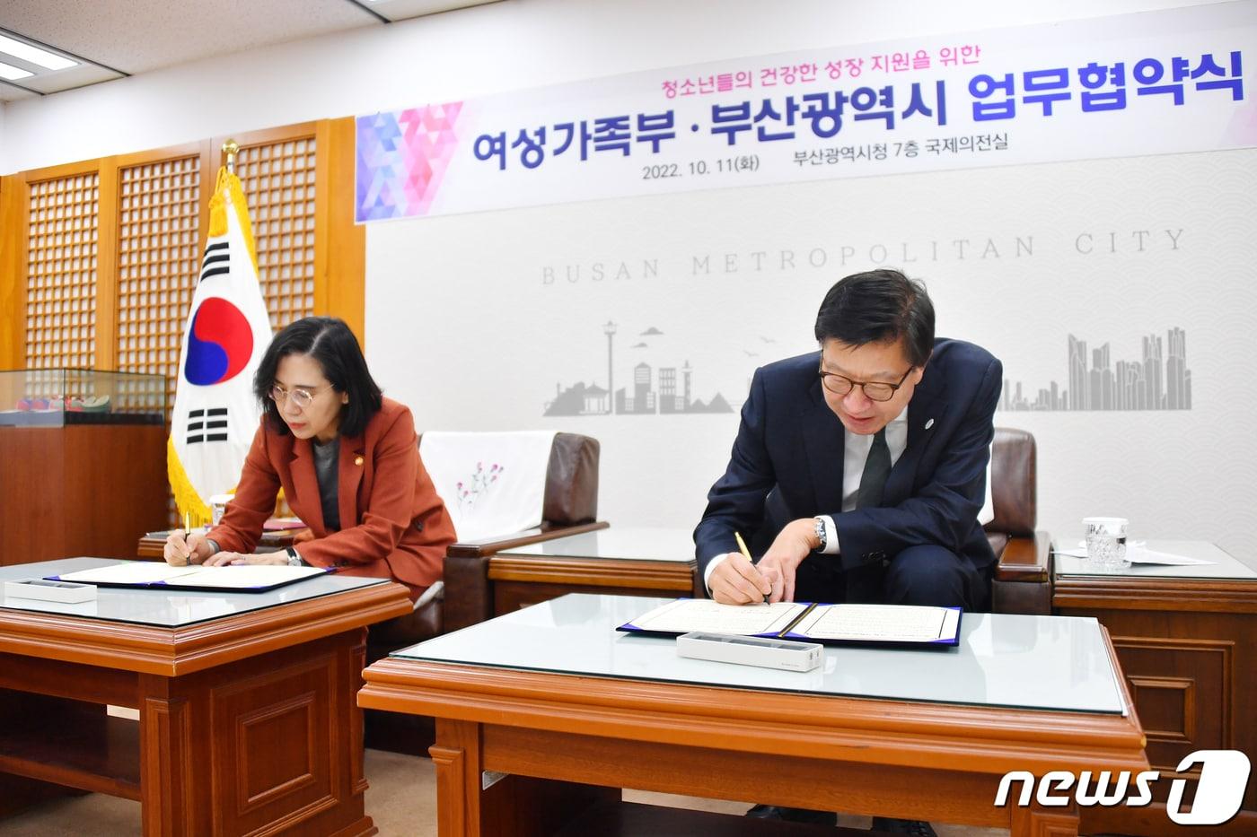 본문 이미지 -  11일 오후 부산시청 국제의전실에서 열린 '청소년들의 건강한 성장 지원을 위한 여성가족부·부산시 업무협약식'에서 김현숙 여가부 장관(왼쪽)과 박형준 부산시장이 업무협약서에 서명을 하고 있다. (부산시 제공)