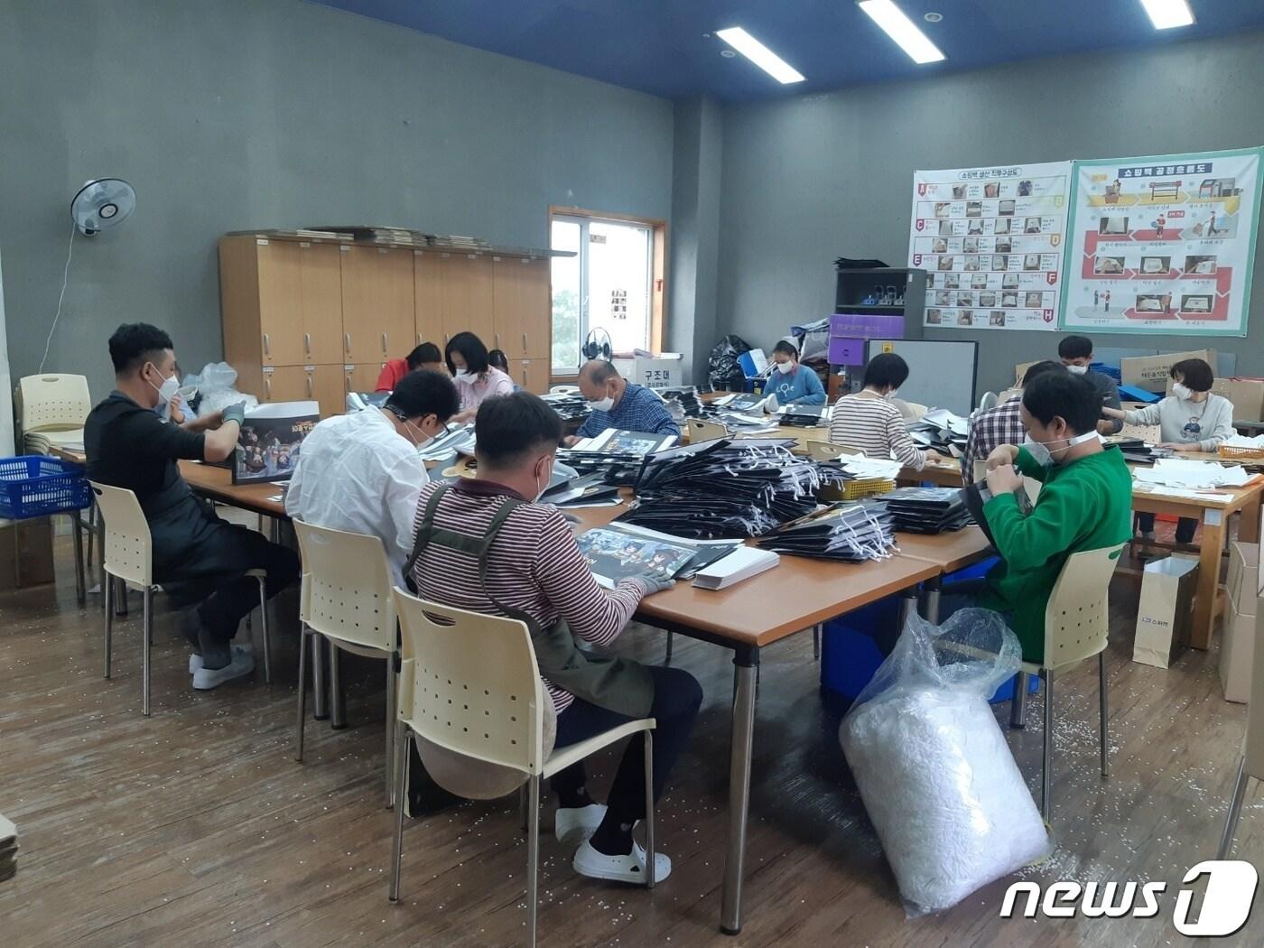 본문 이미지 - 한 직업재활시설에서 근로·훈련 장애인들이 쇼핑백을 생산하고 있는 모습.(용인시 제공)