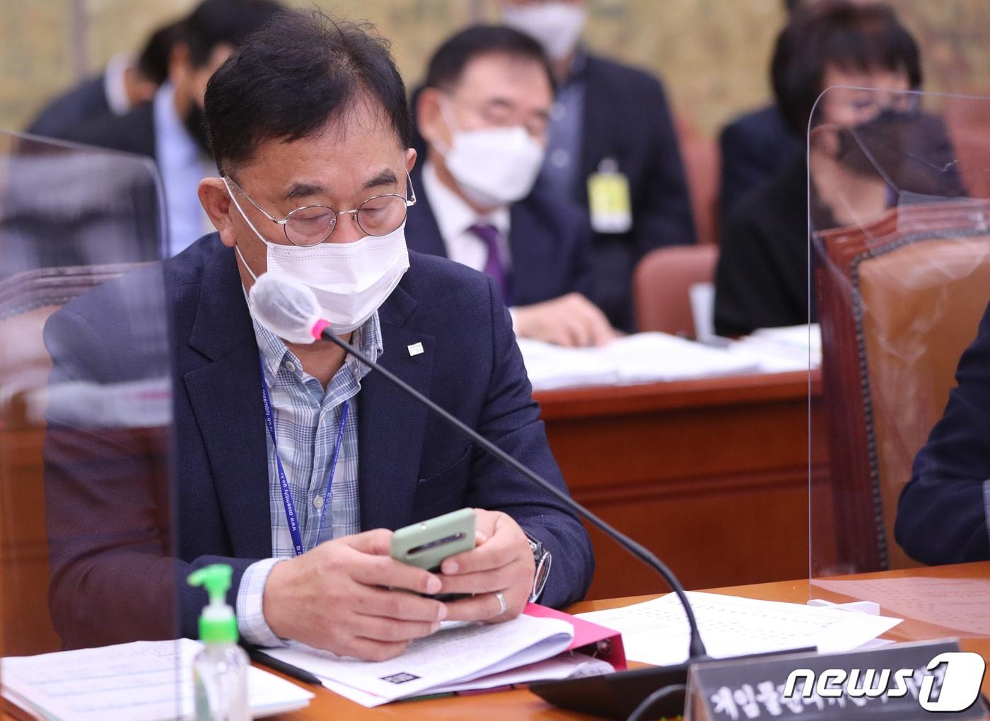 본문 이미지 - 김규철 게임물관리위원회 위원장이 13일 서울 여의도 국회에서 열린 문화체육관광위원회의 한국콘텐츠진흥원 등에 대한 국정감사 중 스마트폰을 보고 있다. 2022.10.13/뉴스1 ⓒ News1 허경 기자