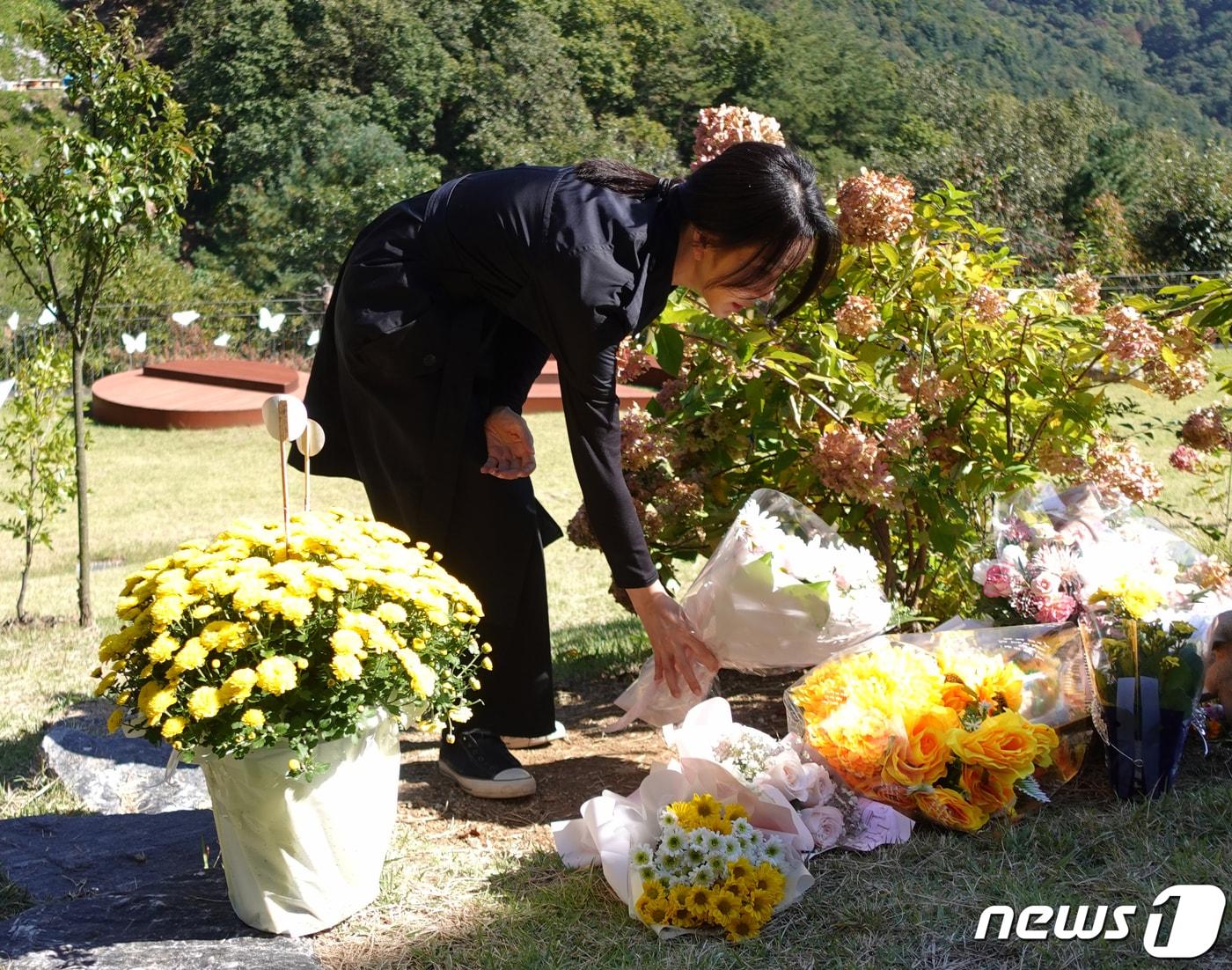 본문 이미지 - 윤석열 대통령 부인 김건희 여사가 '정인이 사건' 2주기를 앞둔 지난 12일 양평 안데르센 메모리얼 파크를 찾아 묘역을 참배하고 고인의 넋을 기렸다. 사진은 묘역에 꽃다발을 놓는 김 여사의 모습. (대통령실 제공) 2022.10.13/뉴스1 ⓒ News1 안은나 기자
