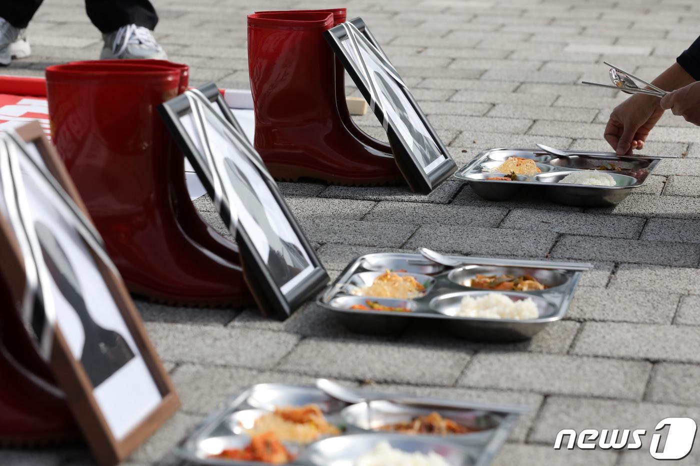본문 이미지 - 지난해 10월 서울 용산구 전쟁기념관 앞에서 열린 전국학교비정규직연대회의 '안전하게 건강하게 일할 권리쟁취 투쟁 선포 기자회견'에서 폐암으로 사망한 급식노동자를 추모하는 식판과 영정이 놓여있는 모습. /뉴스1 ⓒ News1 이승배 기자