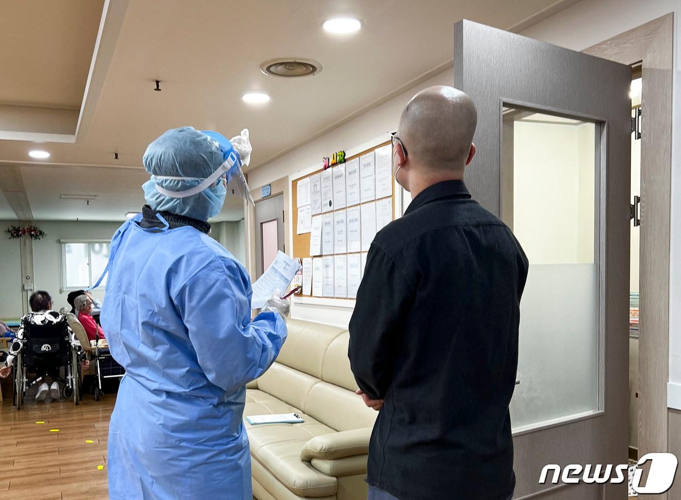 본문 이미지 - 수지구보건소 관계자가 한 요양시설을 방문해 환기시설을 점검하고 있다.(용인시 제공)