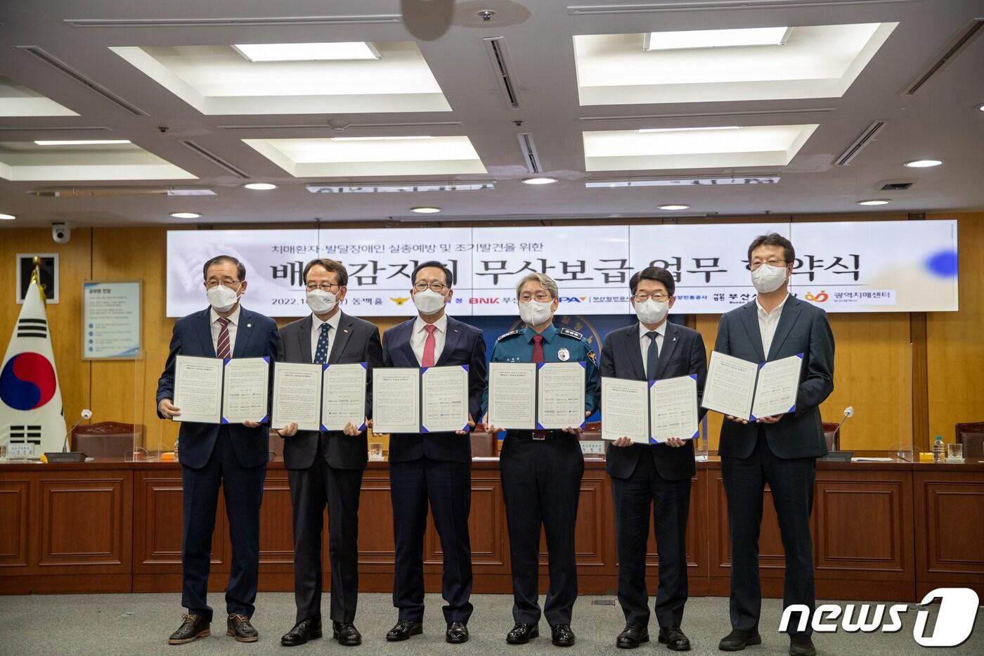 본문 이미지 - 부산경찰청이 BNK 부산은행과 부산항만공사, 한국해양진흥공사, 부산시민재단, 부산광역치매센터와 '치매환자·발달장애인 실종 예방을 위한 배회감지기 무상보급 업무협약’을 맺고 기념사진을 촬영하고 있다.(부산경찰청 제공)