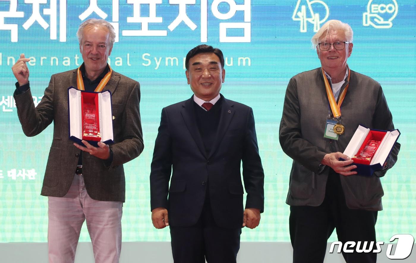본문 이미지 - 김두겸 울산시장이 지난해 10월21일 오후 울산전시컨벤션센터 컨벤션홀에서 열린 '태화강 국가정원 국제 학술토론회'에서 정원작가인 피트 아우돌프(Piet Oudolf)와 바트 후스(Bart Hoes)에게 자연주의 정원 조성에 대한 감사의 뜻을 담은 '울산명예시민증'을 수여한 뒤 기념 촬영을 하고 있다. . 2022.10.21/뉴스1 ⓒ News1 
