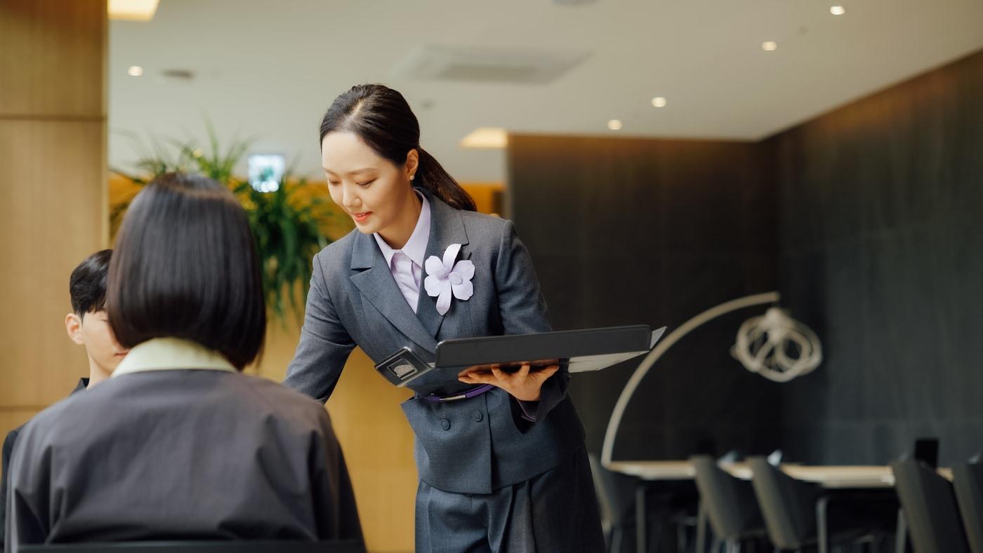 MVG라운지에서 직원이 새로운 유니폼을 입고 고객 응대를 하는 모습(롯데백화점 제공)