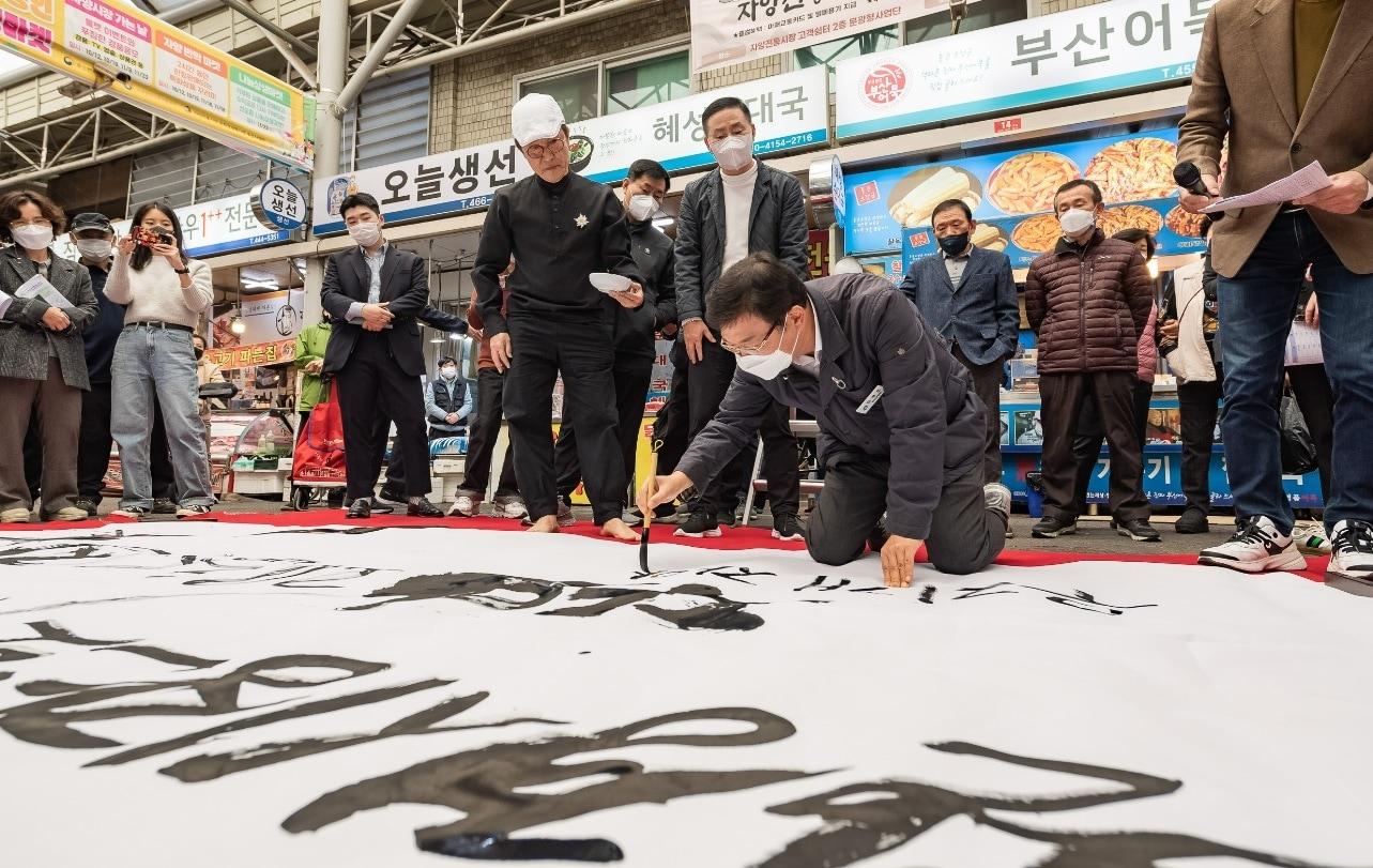 본문 이미지 - 자양전통시장 친환경 시장 투명경영 선포식에서 캘리그래피 퍼포먼스하는 김경호 광진구청장(광진구 제공).
