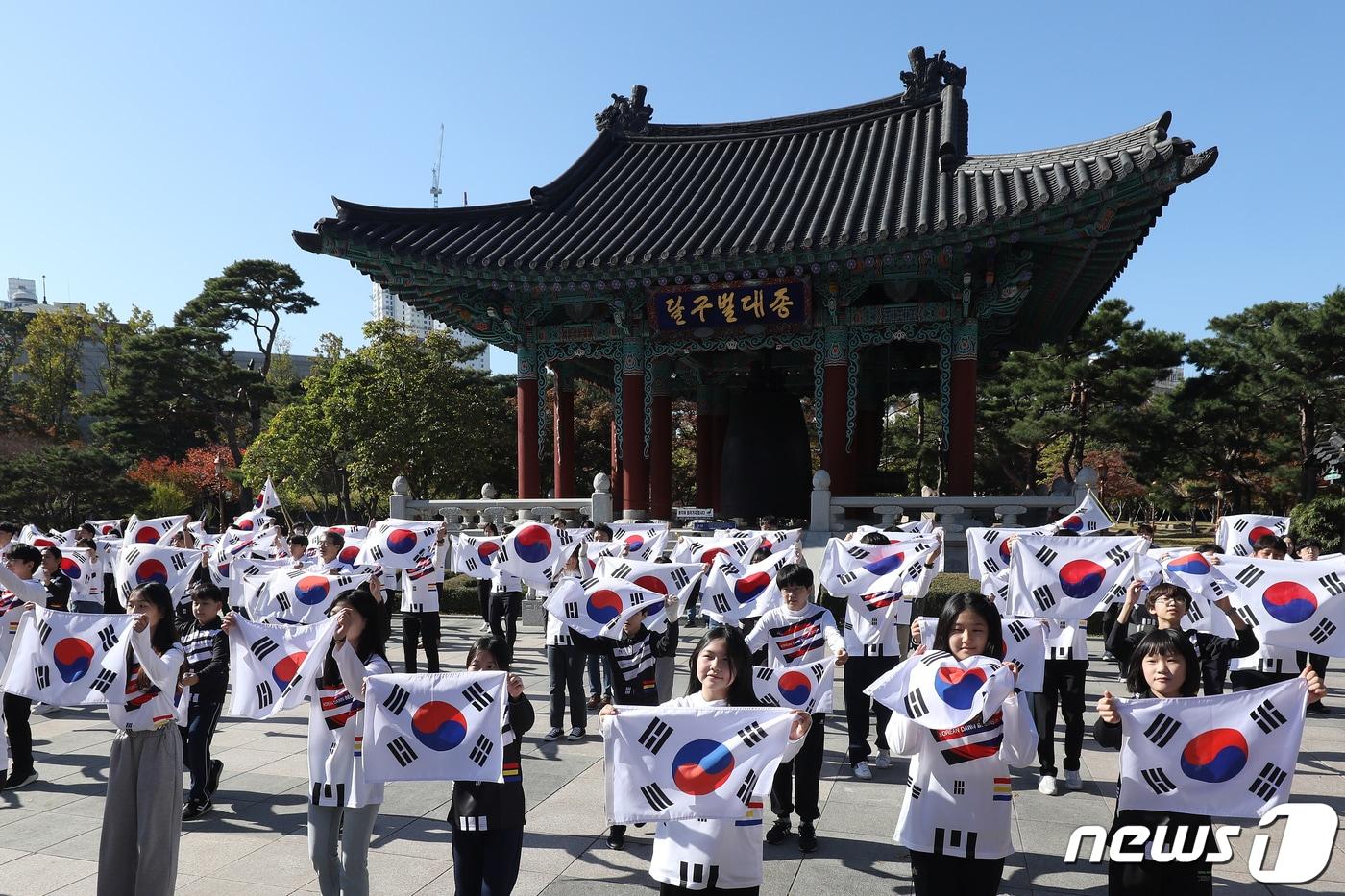 본문 이미지 - 1900년 10월 25일, 고종황제의 대한제국 칙령 제41호 독도주권 선포 122주년을 맞아 25일 오전 대구 중구 국채보상운동기념공원 달구벌대종 앞에서 열린 '2022 독도의 날' 기념행사에 참여한 동덕초등학교 학생과 자원봉사자, 미스대구·경북, 대구시 직원 등 대구시민 122명이 태극기를 흔들며 독도사랑 플래시몹을 펼치고 있다. 2022.10.25/뉴스1 ⓒ News1 공정식 기자