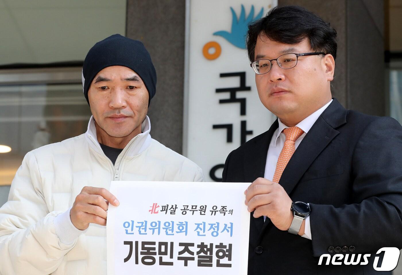 본문 이미지 - 북한군에 피살된 해양수산부 공무원 친형 이래진씨와 김기윤 변호사가 28일 서울 중구 국가인권위원회 앞에서 더불어민주당 기동민 의원과 주철현 의원 진정서를 들어보이고 있다. ⓒ News1 장수영 기자