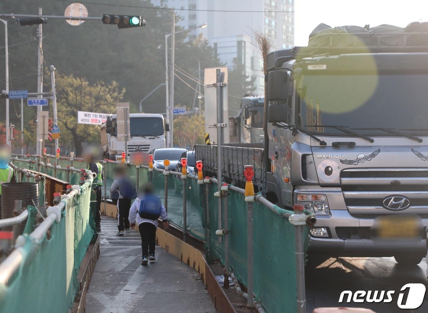 본문 이미지 - 28일 오전 8시쯤 부산 사하구 구평초등학교 학생들이 철제로 된 골목 통학로를 건너고 있다.2022.10.28/뉴스1 노경민 기자