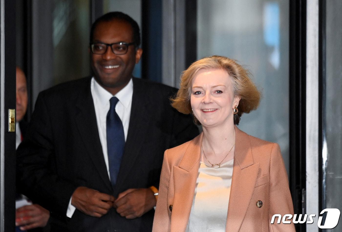 본문 이미지 - 4일(현지시간) 영국 버밍엄에서 보수당 연례 회동에 참석한 리즈 트러스 총리와 쿼지 콰텡 재무장관이 호텔 밖으로 밝게 웃으며 나오고 있다. ⓒ 로이터=뉴스1 