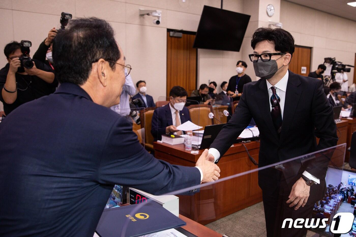 본문 이미지 - 한동훈 법무부 장관이 6일 서울 여의도 국회에서 열린 법제사법위원회의 법무부, 대한법률구조공단, 한국법무보호복지공단, 정부법무공단, 이민정책연구원에 대한 국정감사에서 증인선서문을 김도읍 법사위원장에게 전달한 후 손을 맞잡고 있다. 2022.10.6/뉴스1 ⓒ News1 유승관 기자