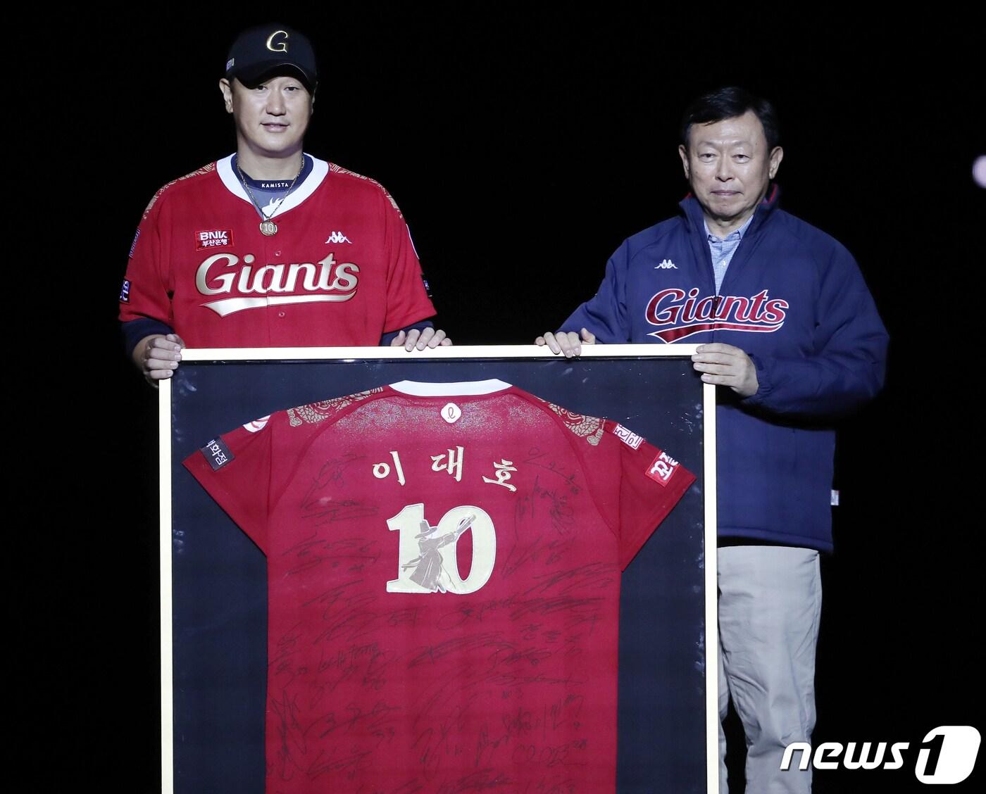 본문 이미지 - 롯데 자이언츠 이대호가 8일 부산 동래구 사직야구장에서 프로야구 '2022 신한은행 SOL KBO리그' LG 트윈스와의 경기가 끝난 후 열린 은퇴식·영구결번식에서 신동빈 롯데 회장에게 선수단 전원 친필 사인이 적힌 자신의 유니폼을 선물하고 있다. 2022.10.8/뉴스1 ⓒ News1 김진환 기자