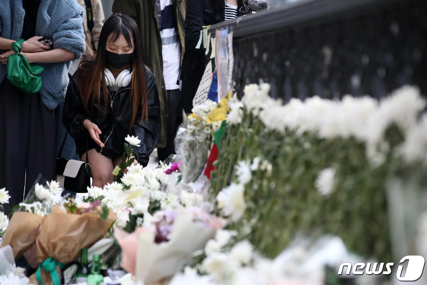 1일 오전 서울 용산구 이태원역 1번 출구에 마련된 이태원 핼러윈 압사 참사 추모공간에서 추모객이 헌화하고 있다. 2022.11.1/뉴스1 ⓒ News1 이승배 기자