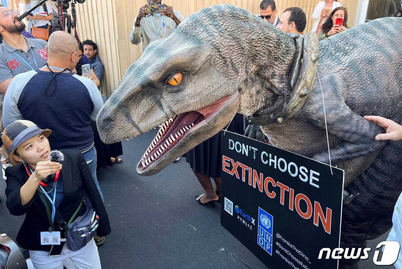 이집트 샤름 알 셰이크에서 2022년 11월 열린 제27차 유엔기후변화협약 당사국회의(COP27) 행사장에서 '멸종을 선택하지 말라'는 안내판을 들고 있는 모습. /뉴스1 ⓒ 로이터=뉴스1 ⓒ News1 황덕현 기자