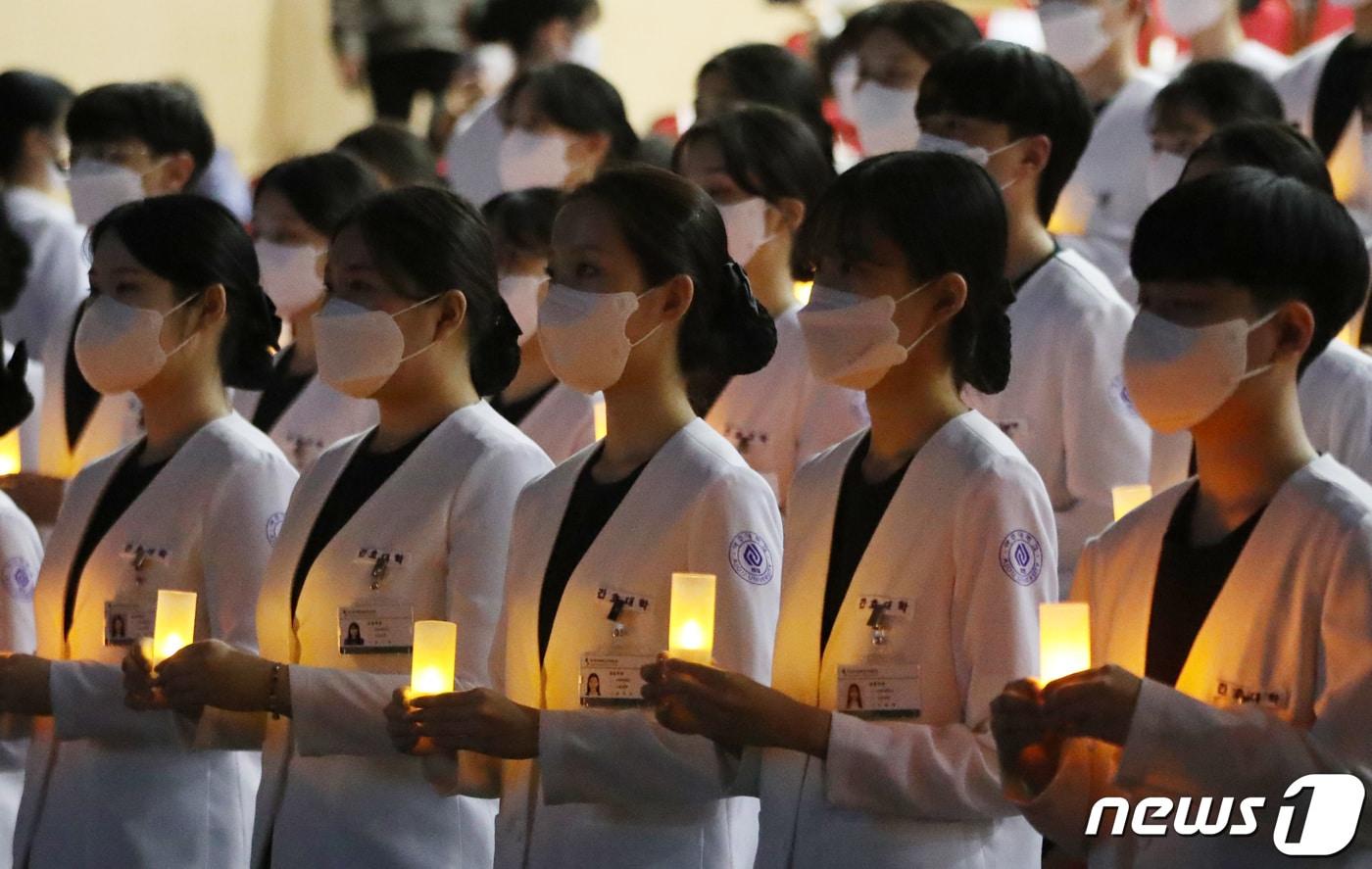 본문 이미지 - 지난 2022년 경기도의 한 대학교 나이팅게일 선서식에서 간호대학 학생들이 촛불의식을 하고 있다.   ⓒ 뉴스1 김영운 기자