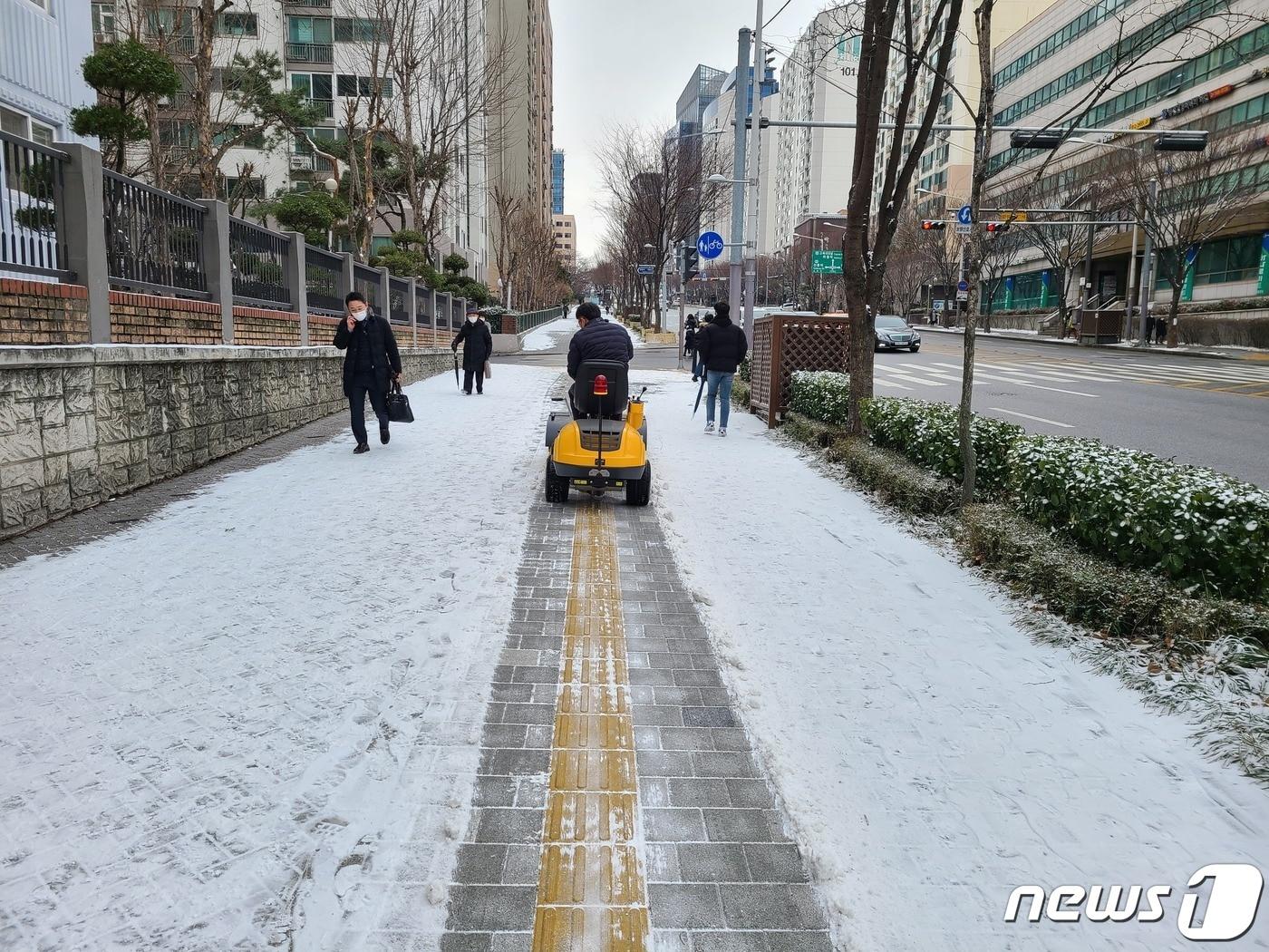본문 이미지 - 제설 브러쉬로 보도 제설 작업을 하는 모습 (강남구 제공). @News1