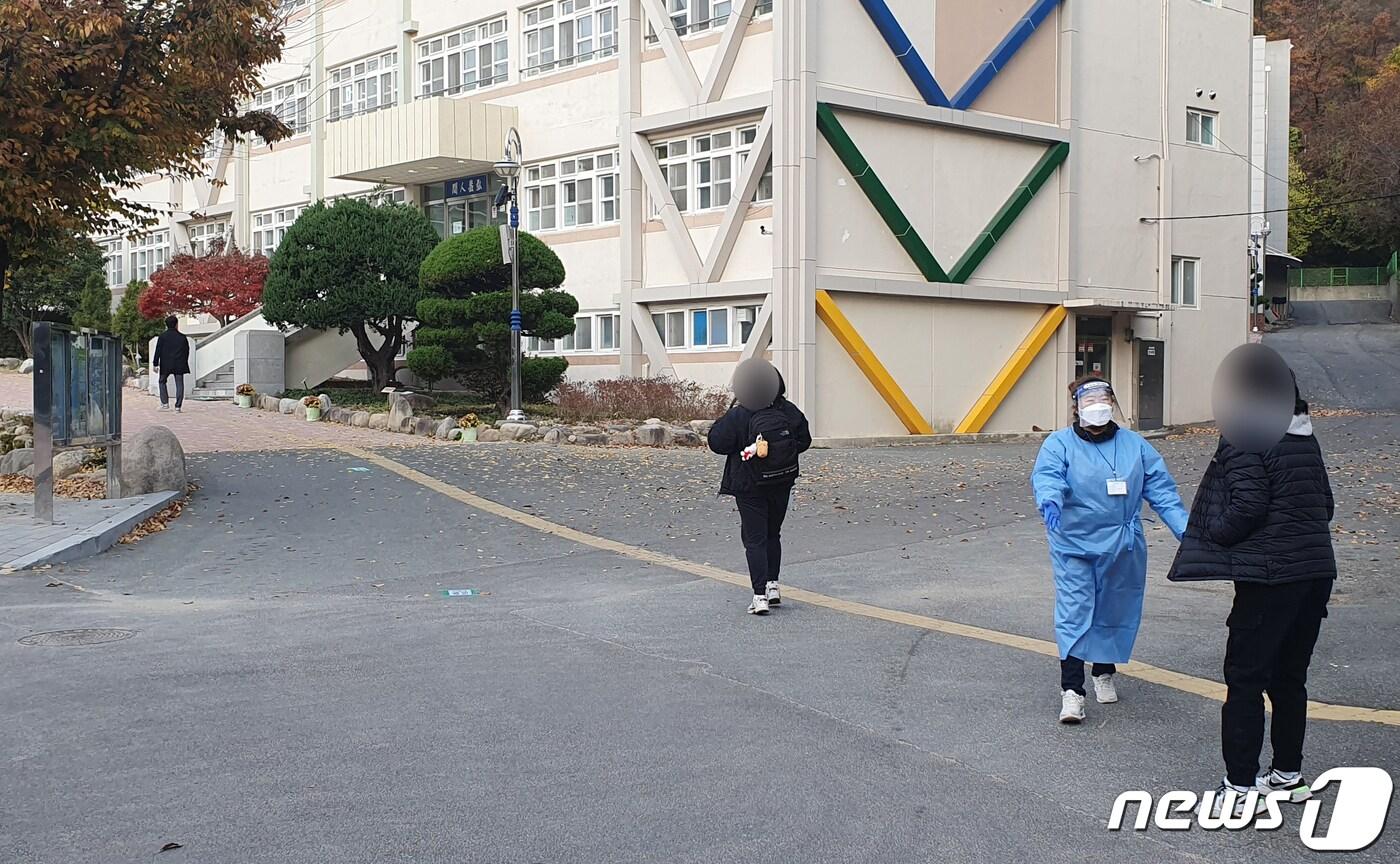 본문 이미지 - 2023학년도 대학수능시험일인 17일 경북 포항시 남·북구 지역 수험생 중 코로나19에 확진된 수험생은 총 23명으로 나타났다. 포항시 북구 모 고등학교에 마련된 특별시험실 앞에서 방역요원이 수험생 보호자를 안내하고 있다.2022.11.16/뉴스1 최창호 기자 