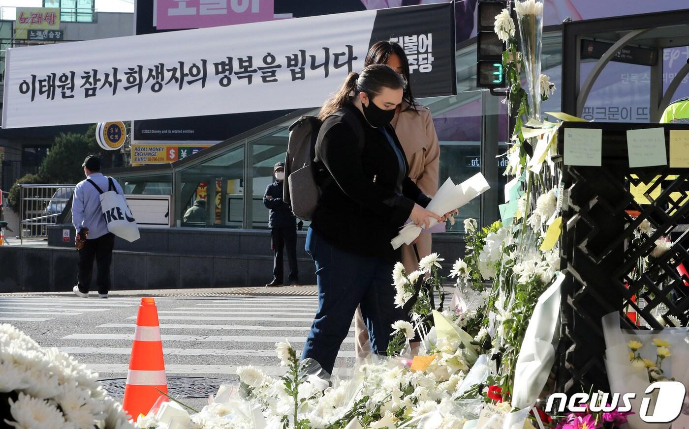 서울 용산구 이태원 참사현장 앞에 마련된 추모공간을 찾은 외국인들이 헌화를 하고 있다. /뉴스1 ⓒ News1 박세연 기자