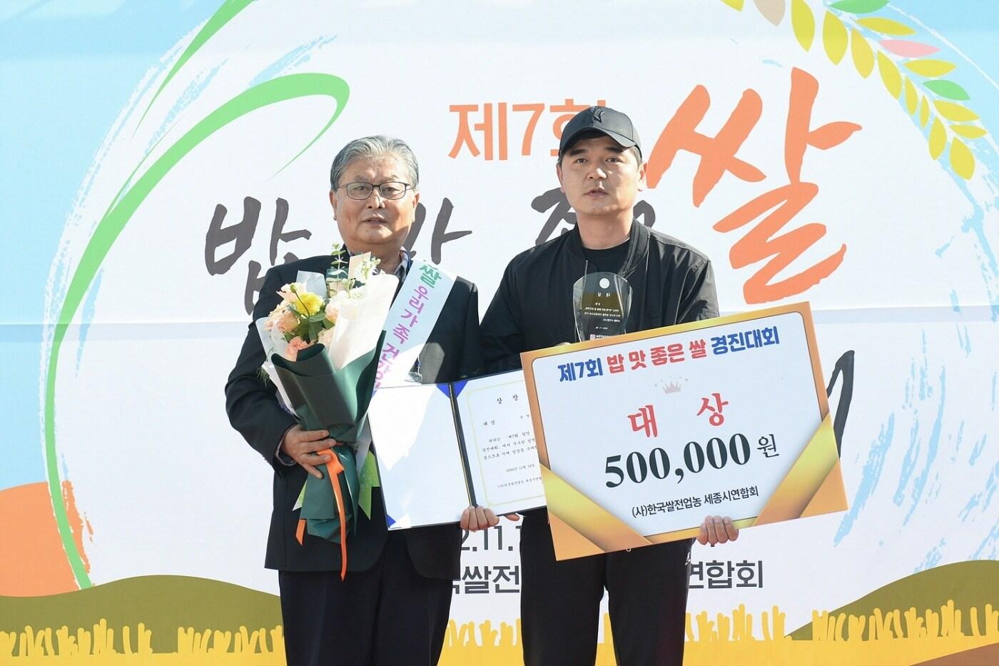 본문 이미지 - 18일 도담동 싱싱장터에서 열린 ‘7회 밥맛 좋은쌀 선정 경진대회'에서 대상을 차지한 배경진씨(오른쪽)와 한국쌀전업농세종시연합회 오흥교 회장이 기념촬영을 하고 있다. (세종시 제공) / 뉴스1 