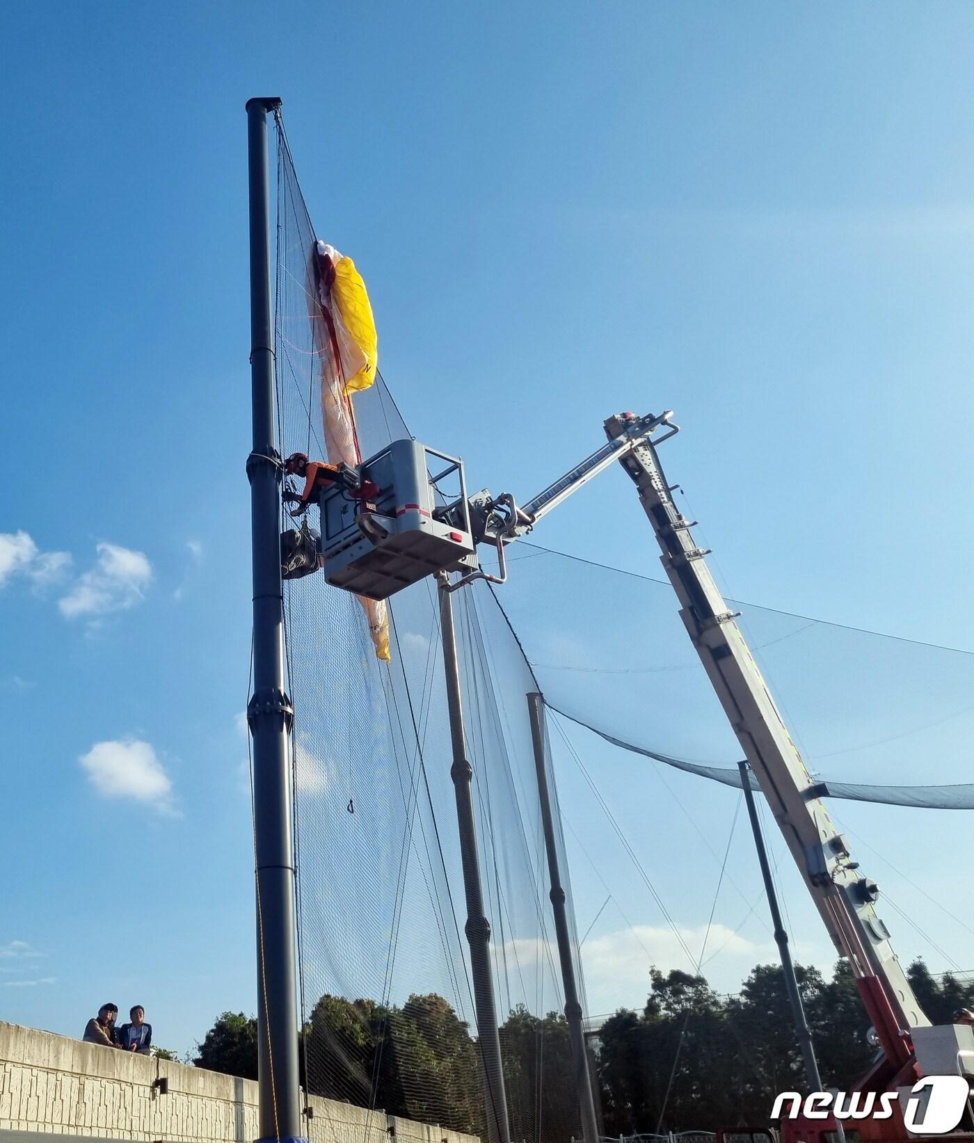 본문 이미지 - 소방대원들이 지난 19일 오후 제주시 한림읍 금악리의 한 야구장 펜스 그물에 걸린 여성을 구조하고 있다.(제주서부소방서 제공)