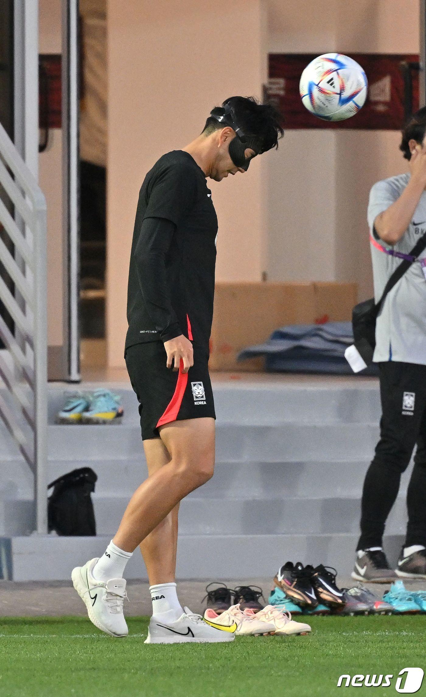 본문 이미지 - 축구 국가대표팀의 손흥민이 21일 카타르 도하의 알 에글라 트레이닝센터에서 마스크를 쓴 채 헤딩을 하고 있다. ⓒ AFP=뉴스1