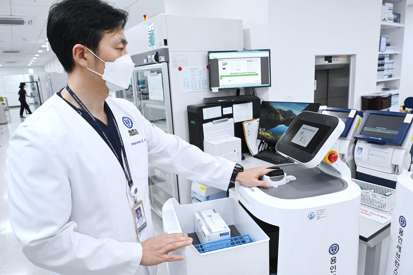 용인세브란스병원 소속 의료진이 LG 클로이 서브봇으로부터 생체인증을 통해 의약품을 수령하고 있다(LG전자 제공).