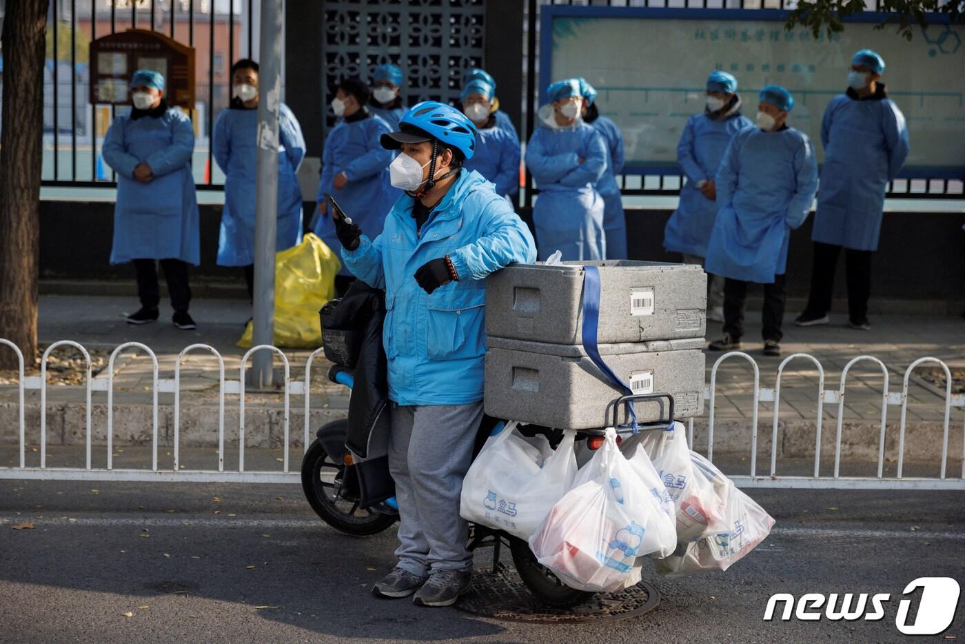 본문 이미지 - 23일 중국 베이징에서 신종 코로나바이러스 감염증(코로나19) 확산이 계속됨에 따라 음식 배달원이 봉쇄된 주거 단지 밖에서 기다리고 있는 모습. 2022.11.23/뉴스1 ⓒ 로이터=뉴스1 ⓒ News1 김민수 기자