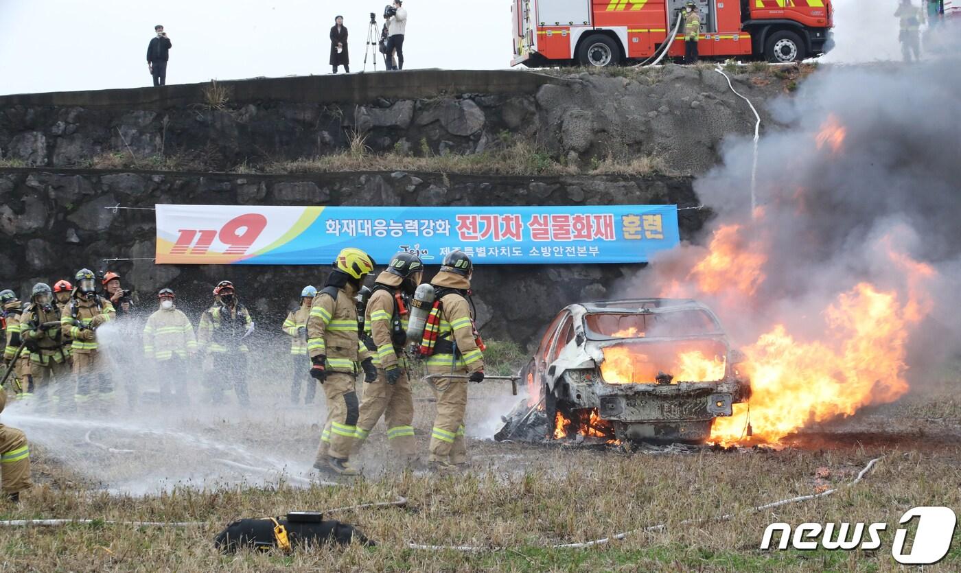본문 이미지 - 제주 소방대원들이 23일 오후 제주시 한천 제1저류지에서 전기차 화재진압 대응능력 향상을 위한 실물화재 훈련을 실시하고 있다. 2022.11.23/뉴스1 ⓒ News1 오현지 기자