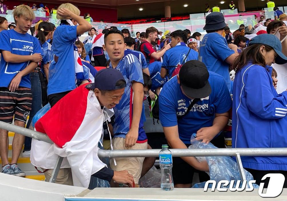 본문 이미지 - 27일 오후(현지시간) 카타르 알라이얀 아흐메드 빈 알리 스타디움에서 2022 카타르 월드컵 조별리그 E조 2차전 일본과 코스타리카의 경기가 끝난뒤 일본 응원단이 쓰레기를 정리하고 있다. 2022.11.27/뉴스1 ⓒ News1 이광호 기자