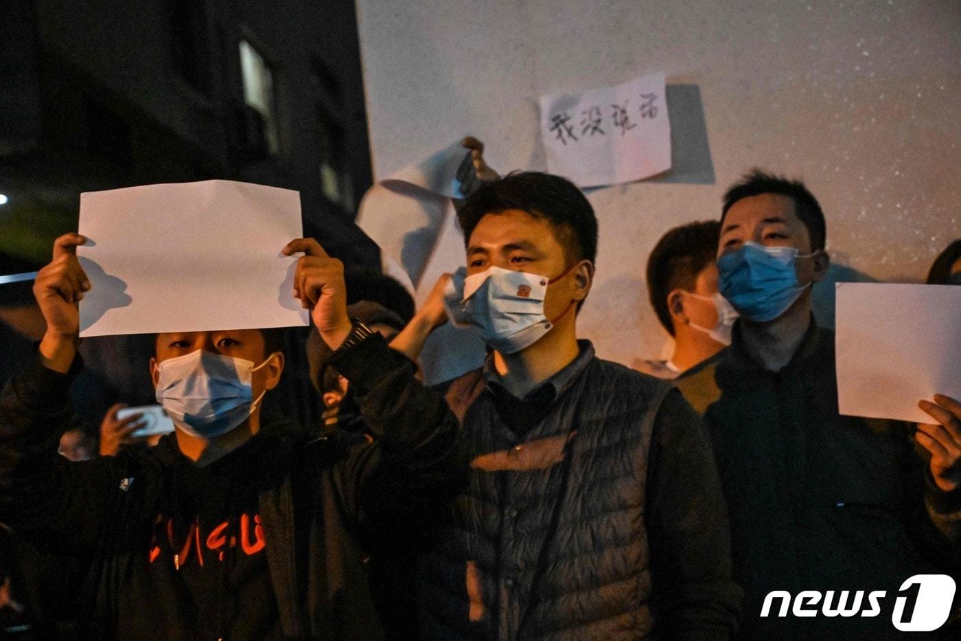지난해 11월27일(현지시간) 중국 상하이에서 정부의 고강도 제로 코로나19 봉쇄 정책에 항의하고 우루무치 화재 희생자를 추모하는 주민들이 정부에 항의하는 의미를 담은 ‘백지’를 들고 시진핑 주석의 퇴진을 요구하는 밤샘 시위를 하고 있다. ⓒ AFP=뉴스1 ⓒ News1 우동명 기자
