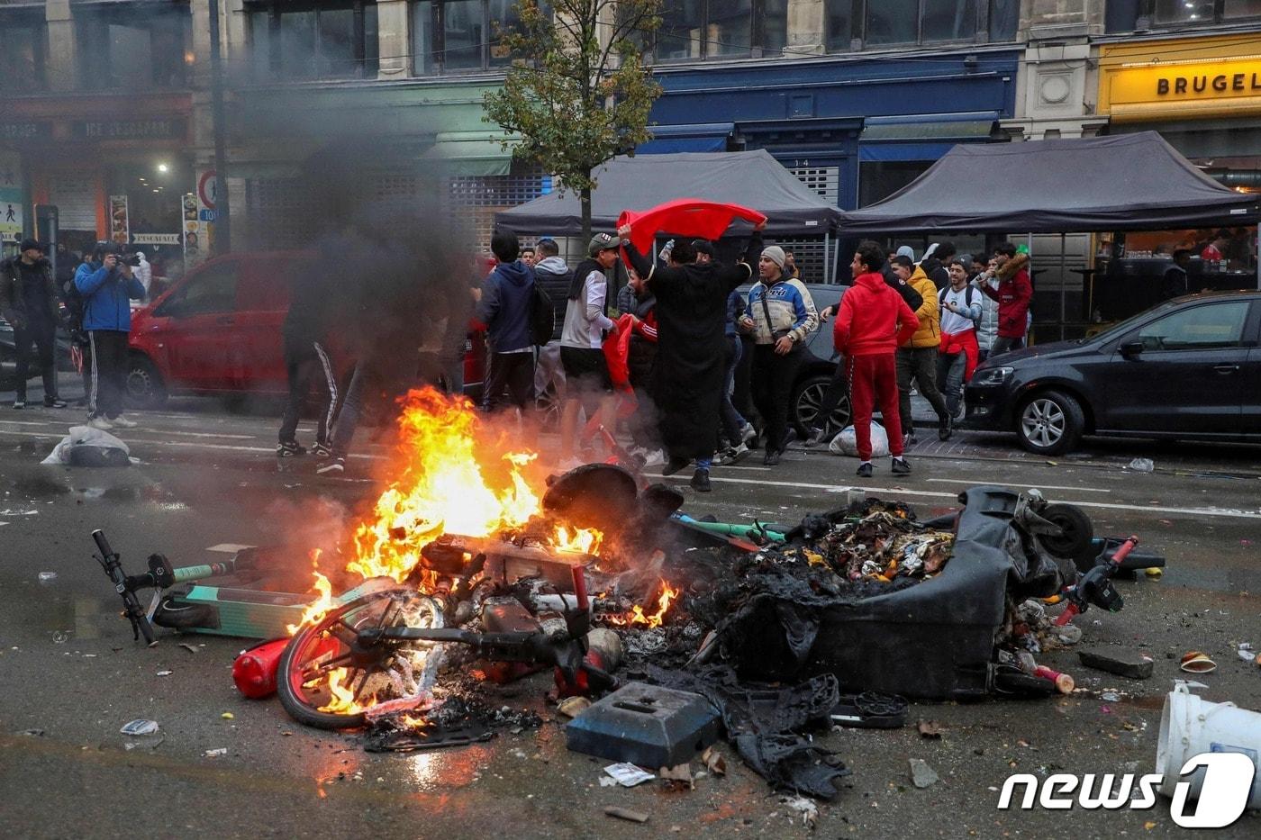 본문 이미지 - '2022 국제축구연맹 카타르 월드컵' 조별리그 F조 경기에서 모로코가 벨기에를 2대 0으로 꺾은 27일(현지시간) 벨기에 브뤼셀 중심가에서 모로코 응원단이 기뻐하는 모습. 부서지고 불에 탄 오토바이도 보인다. 2022. 11. 27. ⓒ AFP=뉴스1 ⓒ News1 최서윤 기자