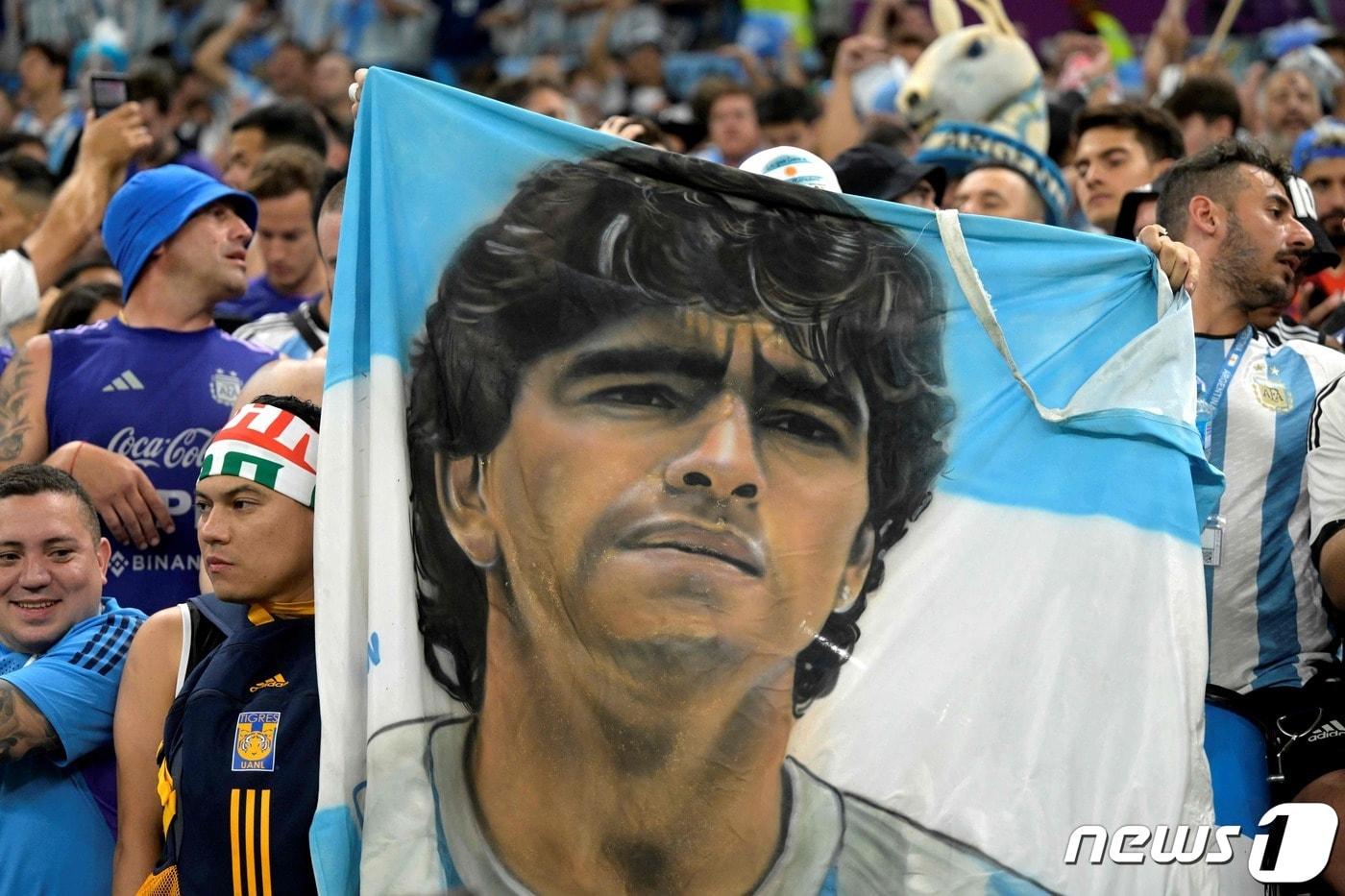 아르헨티나 팬들이 26일(현지시간) 도하 북부 루사일 스테디움에서 멕시코와의 C조 조별리그 경기를 앞두고 자국 전설적인 축구선수 고(故) 디에고 마라도나가 그려진 현수막을 들고 있다. 이날 아르헨티나는 멕시코를 2대 0으로 꺾었다. 2022. 11. 26. ⓒ AFP=뉴스1 ⓒ News1 최서윤 기자
