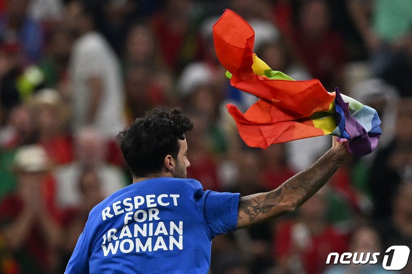 29일(한국시간) 열린 2022 카타르 월드컵 포르투갈과 우루과이 경기 도중 한 남성이 그라운드에 난입해 질주하고 있다. ⓒ AFP=뉴스1