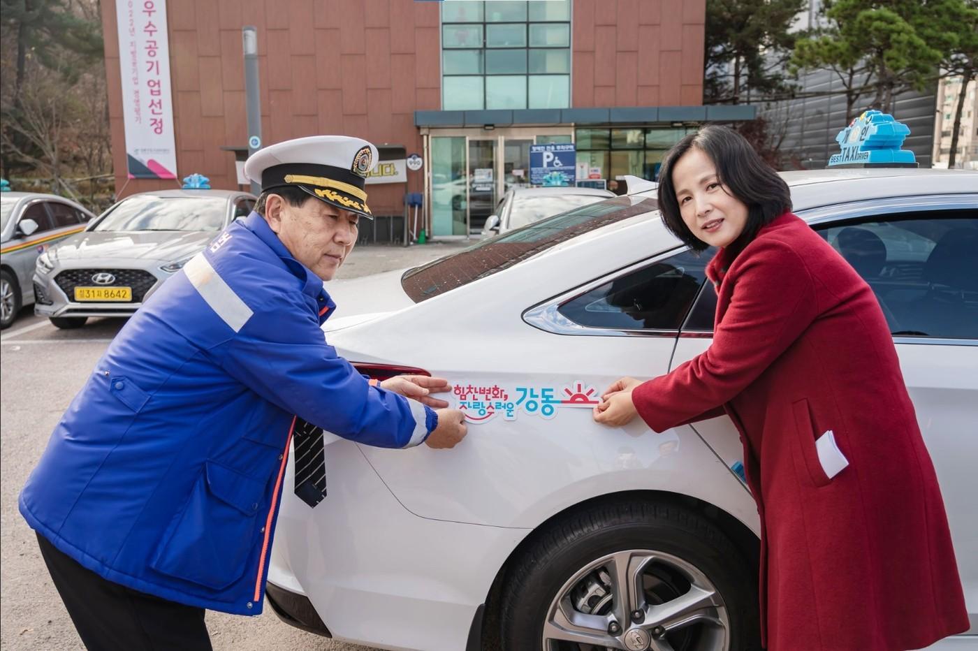 본문 이미지 - 이수희 강동구청장이 구정목표 BI 차량용 자석을 택시에 부착하고 있다(강동구 제공).
