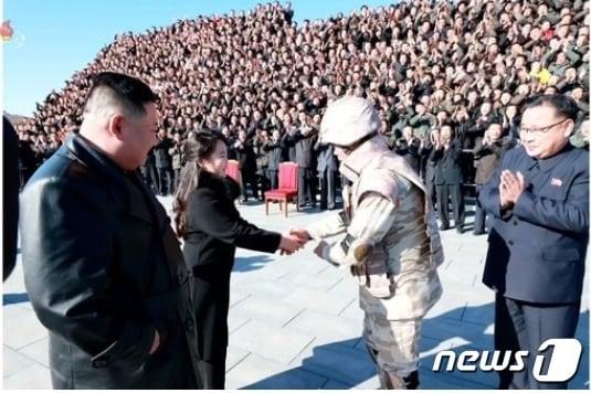 본문 이미지 - 지난 27일 조선중앙TV는 대륙간탄도미사일 화성17형 개발과 발사 공로자들의 기념 촬영 소식을 전하면서 김정은 국무위원장이 "존귀하신 자제분과 함께 촬영장에 나왔다"고 해 주목을 끌었다. 미사일 발사 성공으로 상장에서 대장으로 진급한 장창하가 김정은 위원장의 딸 김주애에게 허리를 숙여 인사, 4대 세습작업에 들어갔다는 해석을 낳았다. (조선중앙TV 갈무리) ⓒ 뉴스1 