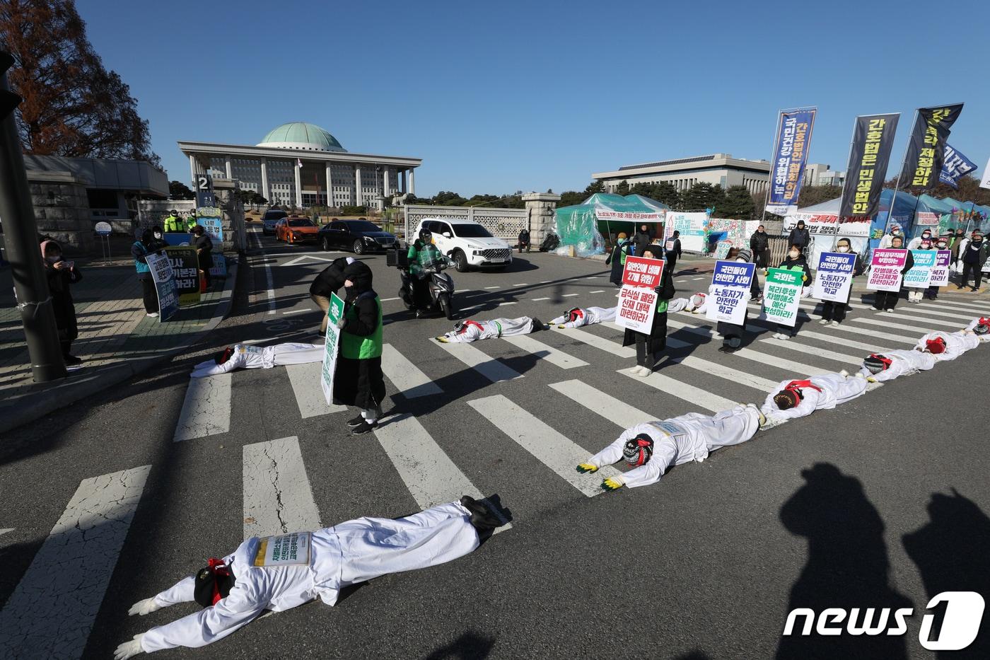본문 이미지 - 공공운수노조 전국교육공무직본부 소속 조합원들이 지난해 11월30일 국회 앞에서 학교 급식실 산업재해 대책 마련 등을 촉구하며 오체투지(五體投地)를 하고 있다. ⓒNews1 신웅수 기자