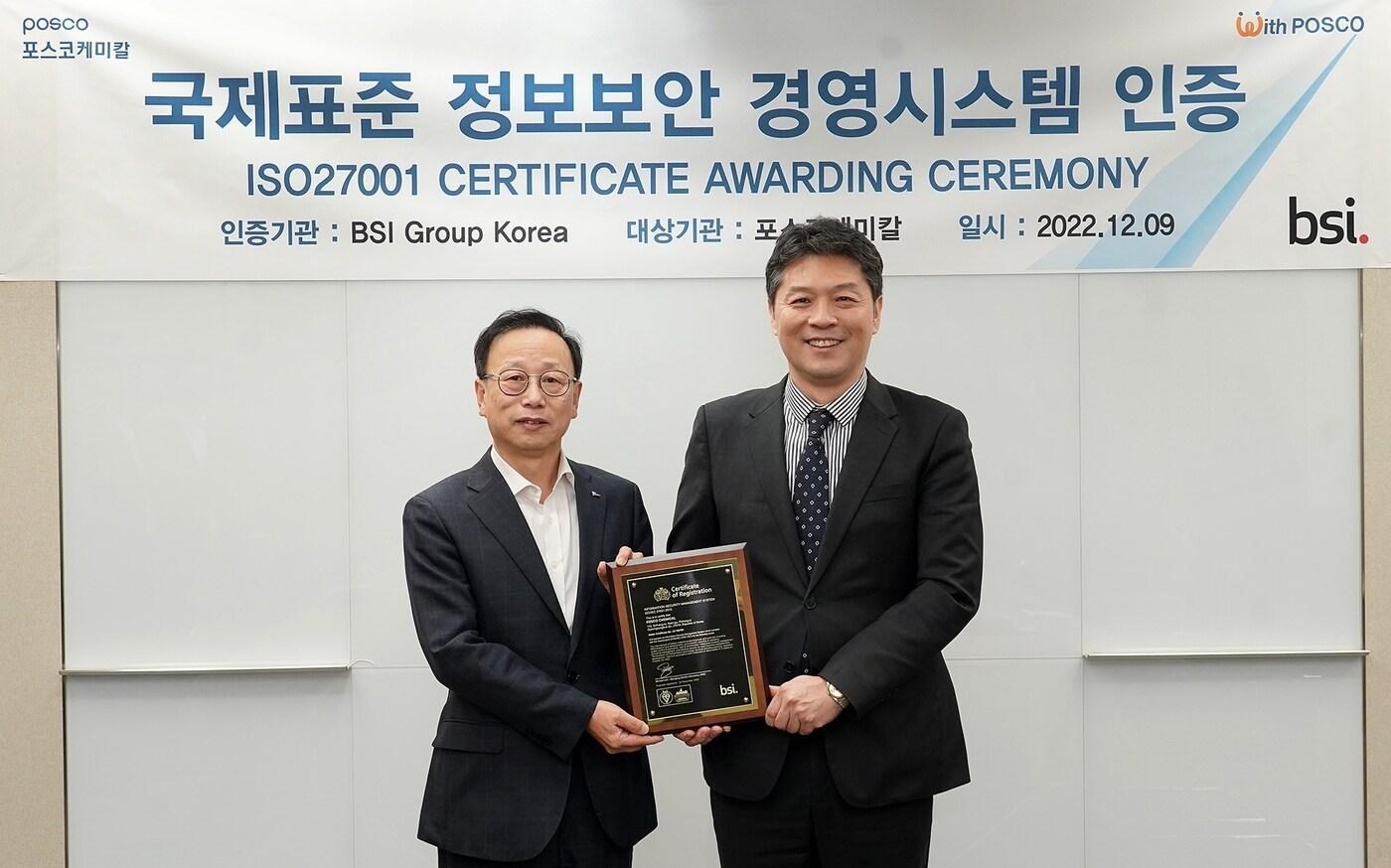 본문 이미지 - 포스코케미칼이 정보보안 경영시스템 인증 ISO27001을 획득하며 핵심기술 보호를 위한 정보보안 역량을 인증 받았다. 지난 9일 서울사무소에서 진행된 인증서 수여식에서 김주현 기획지원본부장(사진 왼쪽)과 BSI Korea 임성환 대표가 인증패를 들고 기념촬영하고 있다. (사진제공=포스코케미칼)